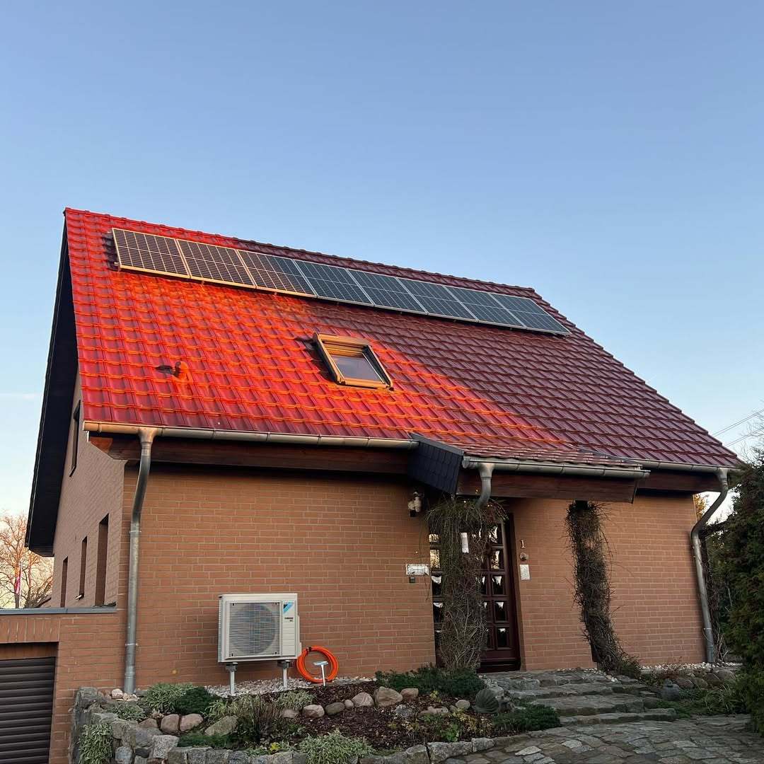 Klinkerhaus mit rotem Ziegeldach und 6,08-kWp-Photovoltaikanlage im Abendlicht